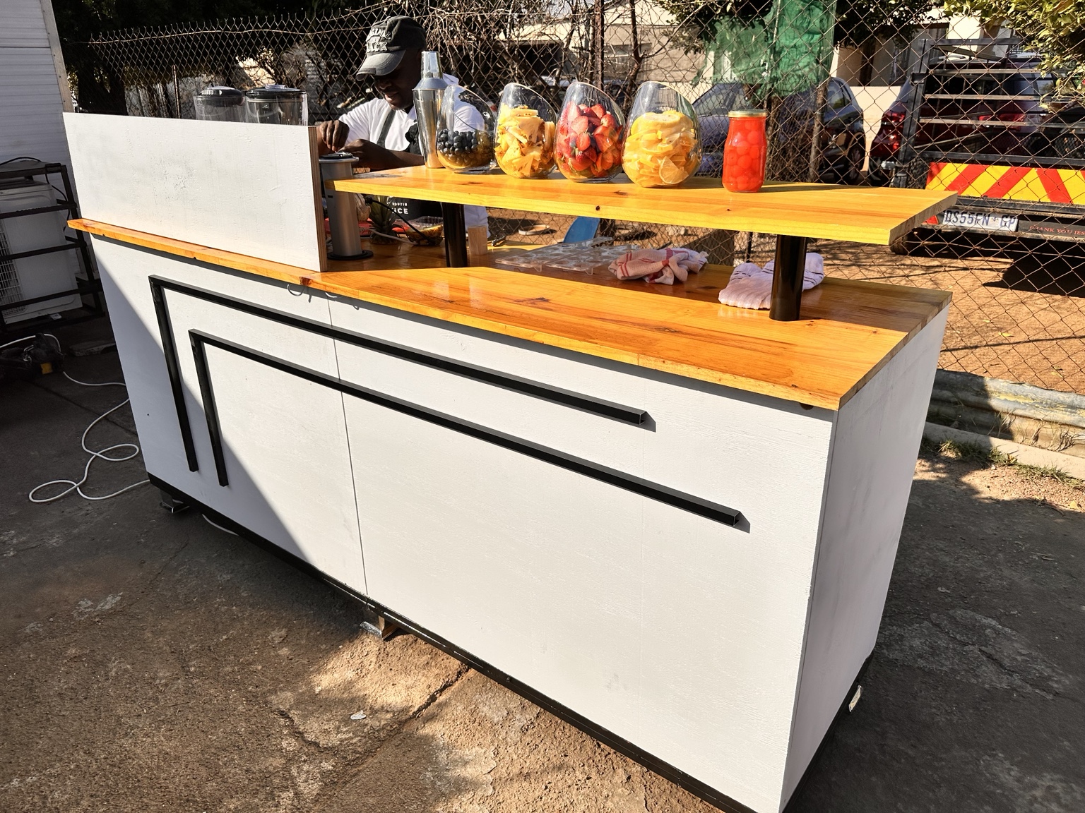 Side view of the mobile bar stocked with fruit garnishes and drinks